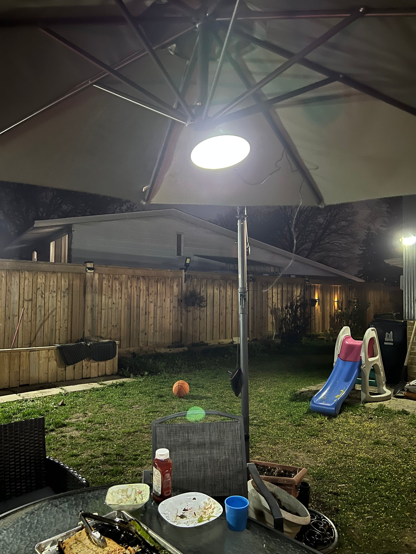 Image of BigM Dual Headed 32 LED Bright Solar Lamp for gazebo installed under a large patio umbrella brightens up the table at night