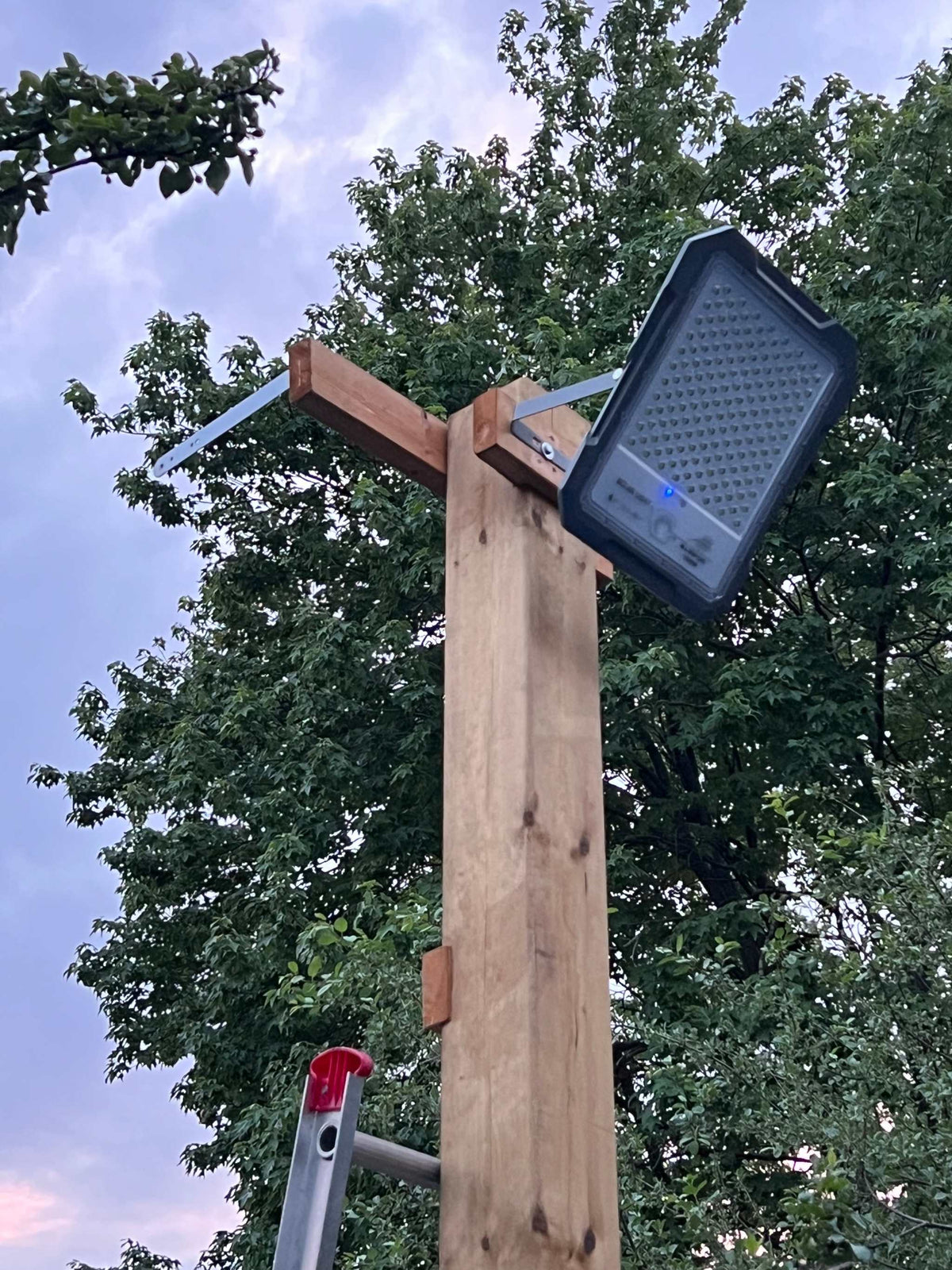 BigM 1500W High Lumens Solar Flood Light is installed on a 6 x 6 post above a picked ball play groud.