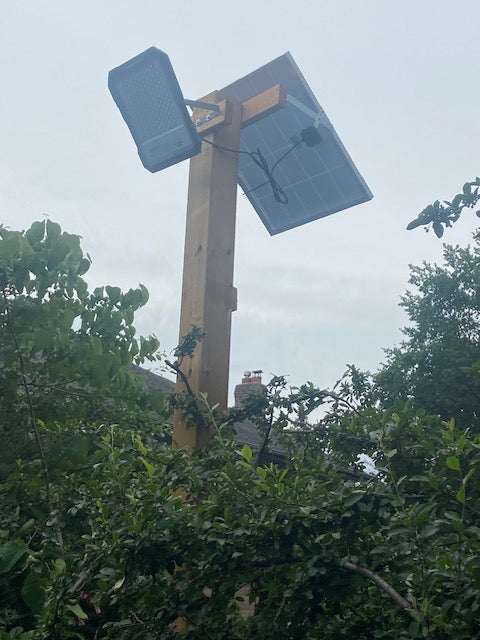 BigM 1500W High Lumens Solar Flood Light is installed on a 6 x 6 post above a picked ball play groud.