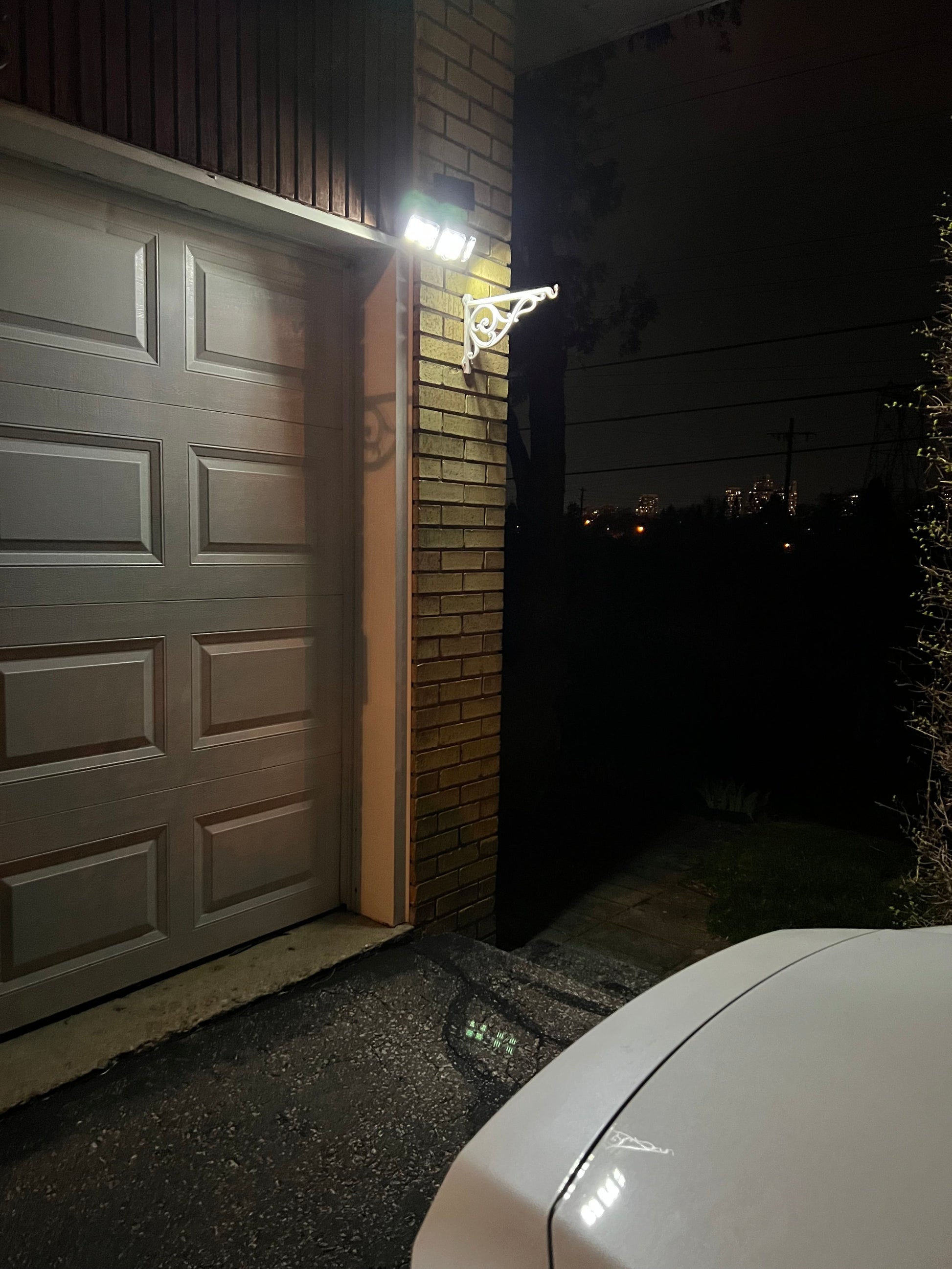 BigM 122 LED adjustable solar security motion sensor light installed at the top of a garage doors to ensure security of the landlord