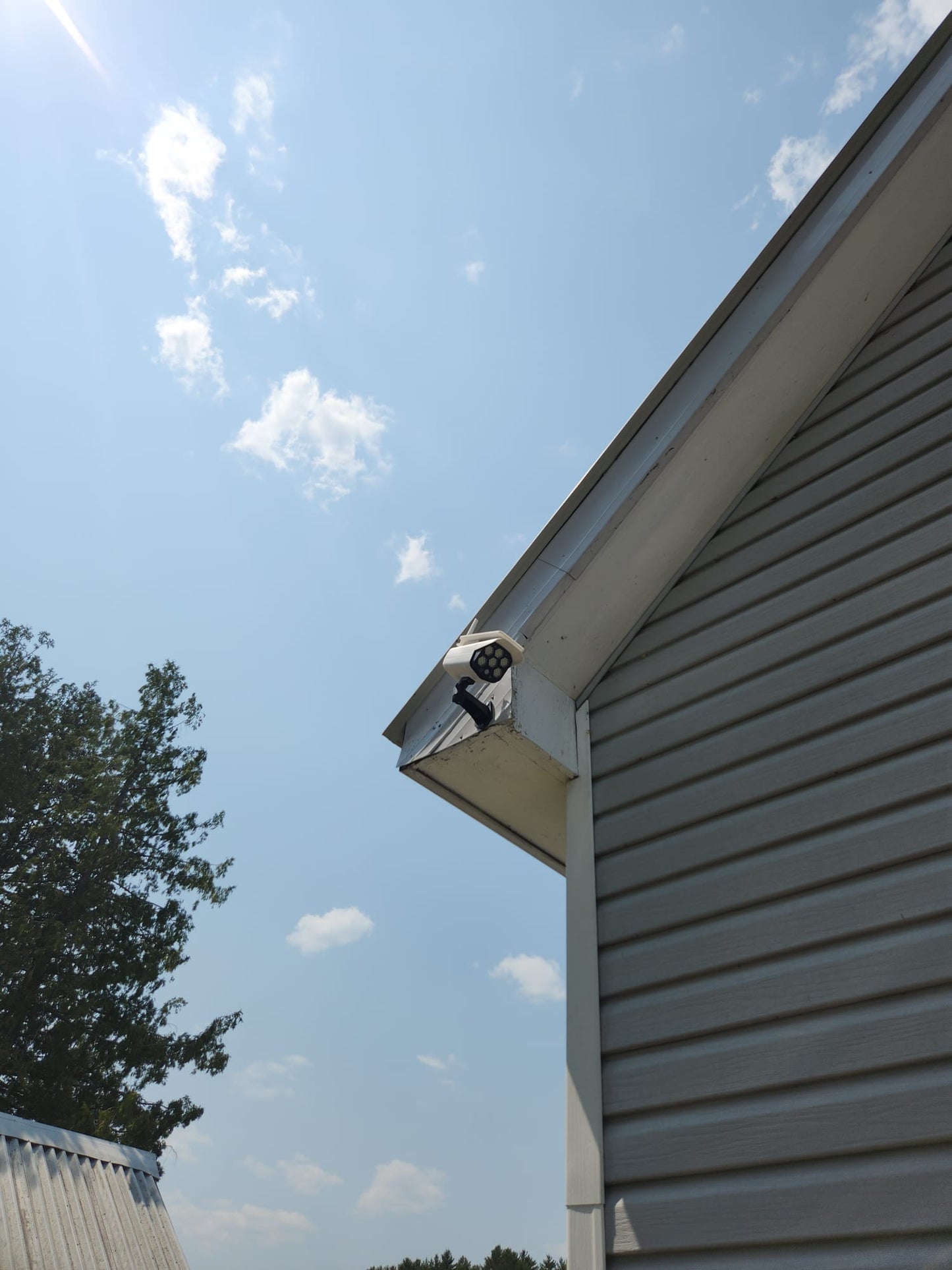 BigM Solar Fake Security Camera Floodlight is installed at the front side of a cottage