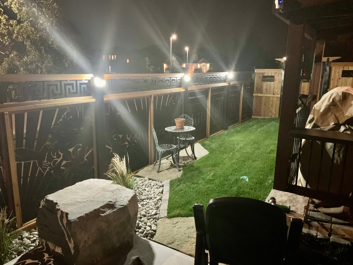 BigM  212 LED Best Solar Light shines on on the fence posts of a backyard