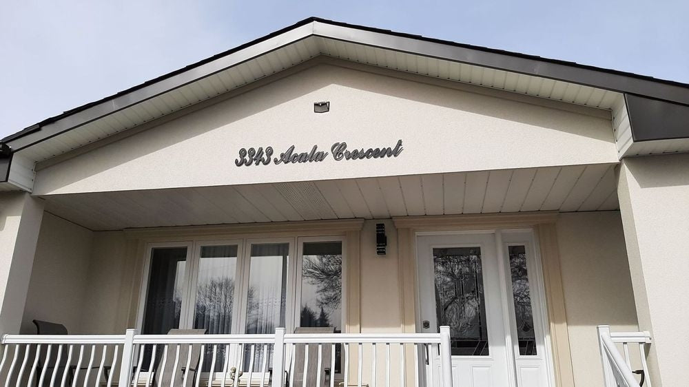 BigM  212 LED Solar Security Light is installed at the top of a house address signage