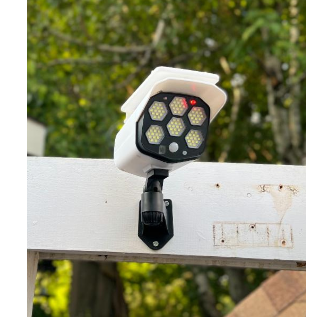 BigM Solar Fake Security Camera Floodlight with Motion Sensor is installed above a garage door of a house