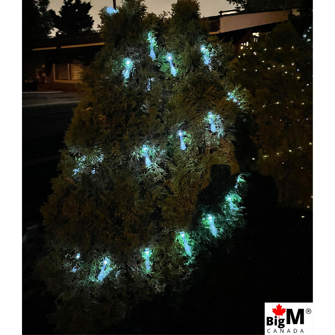 Night view image of BigM Raindrop shaped Cool White glowing Outdoor Solar String Lights installed around a christmas tree