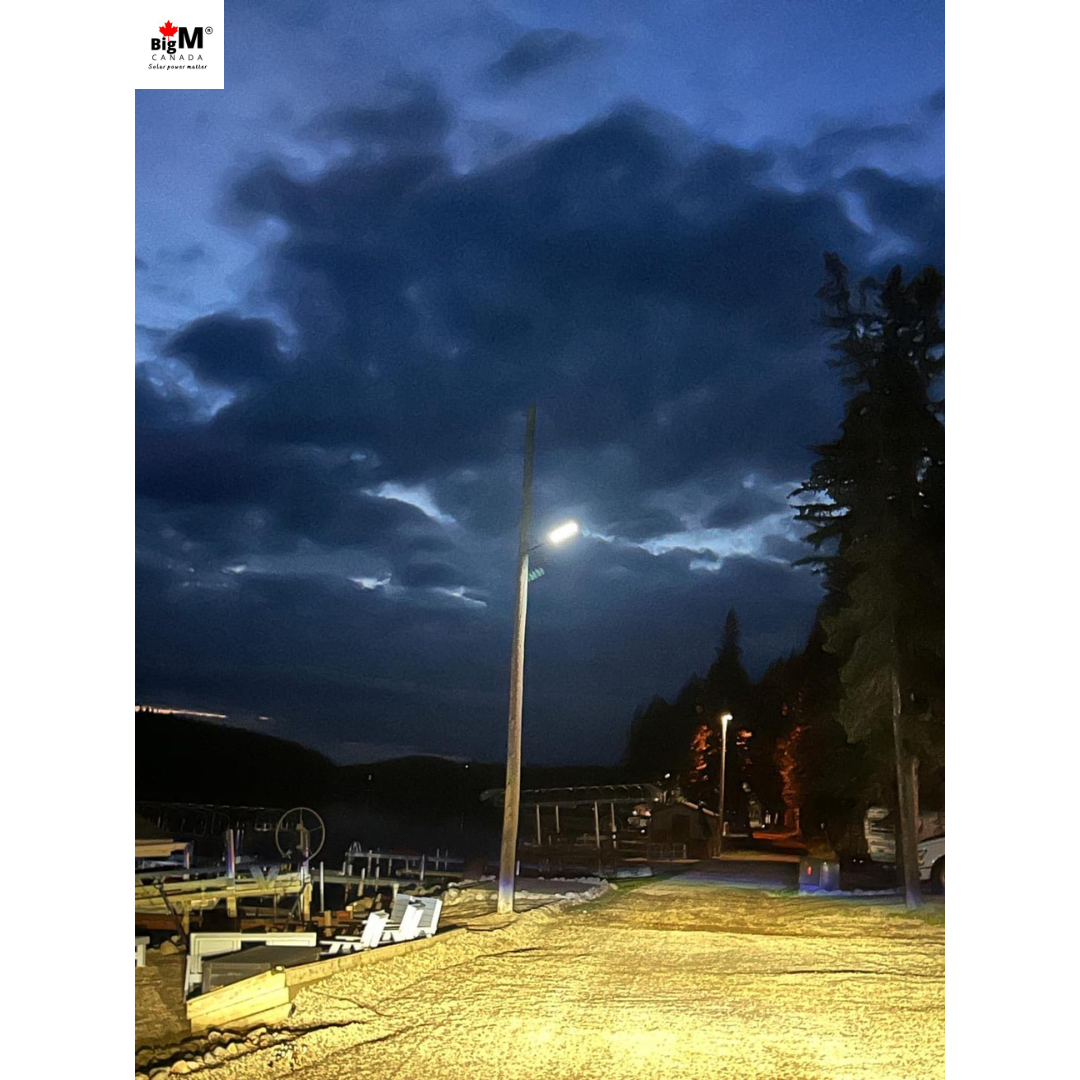 A BigM 1200W solar commercial street lights shining with a impressive brightness on a country road at night.