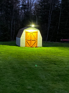 BigM 300W & 15000 Lumens Commercial Graded Solar Street Light with a Large Solar Panel, Aluminum Lamp Body is installed at the top of a garden shade to illuminate a large backyard