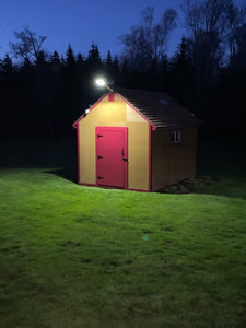 BigM 300W & 15000 Lumens Commercial Graded Solar Street Light with a Large Solar Panel, Aluminum Lamp Body is installed at the top of a garden shade to illuminate a large backyard at Prince Edward Island