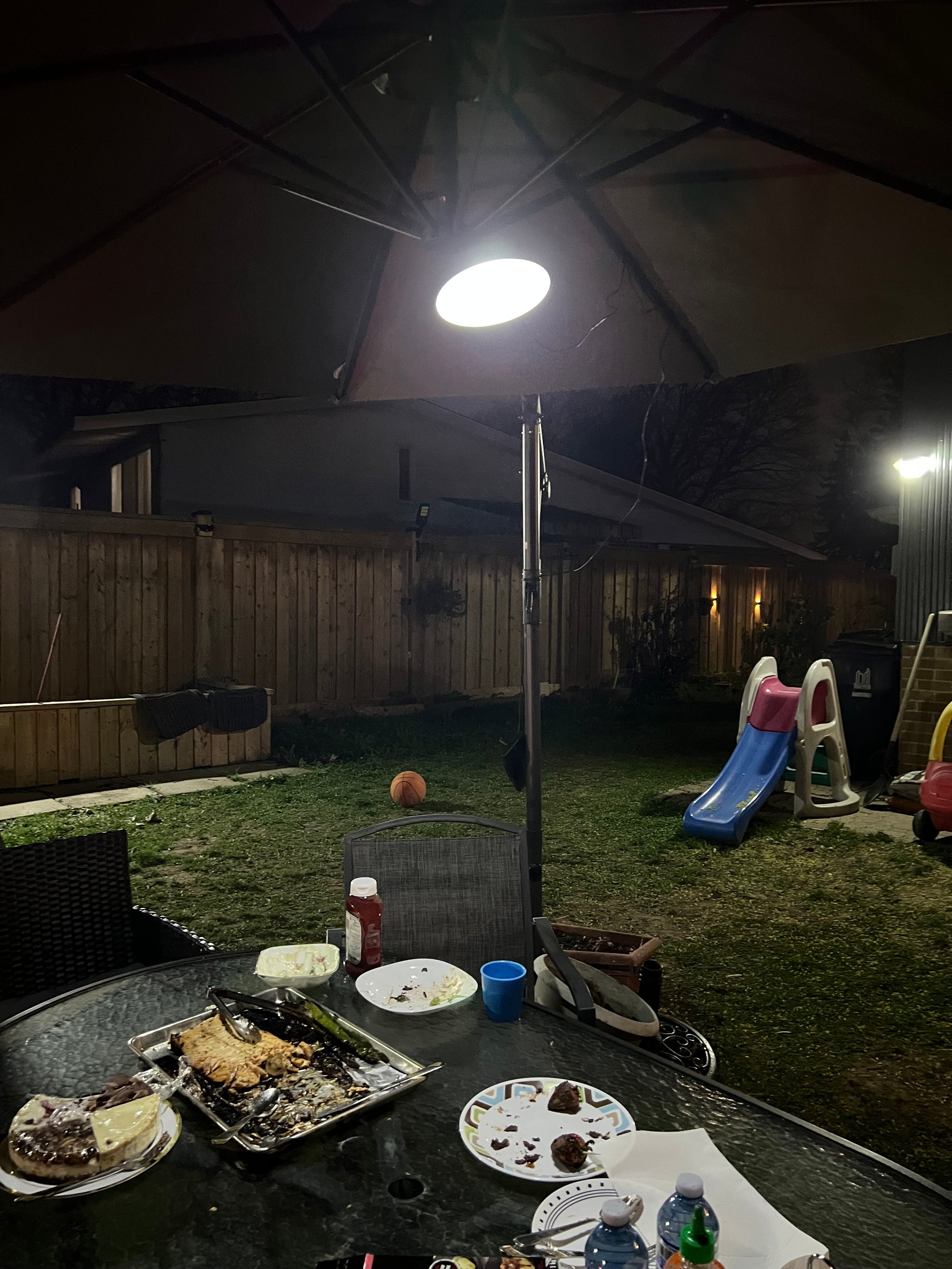BigM 16 LED Solar Light for Indoor is installed under a large patio umbrella and brightens up the table at night.