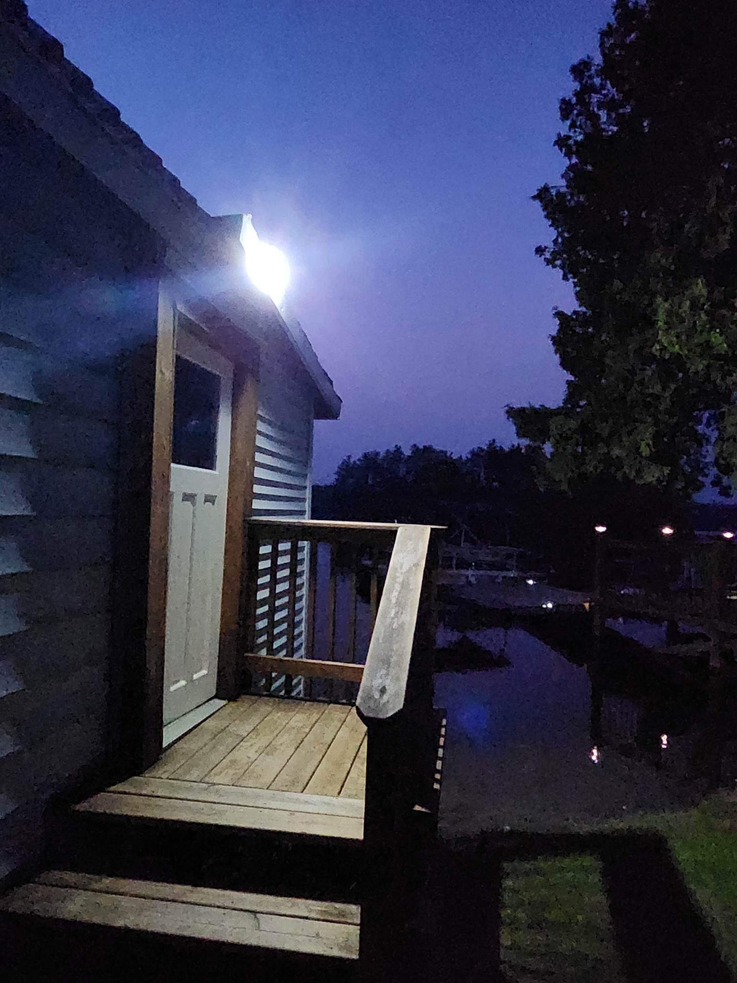 BigM 190 LED Bright Outdoor Solar Security Lights with Motion Sensor illuminates a staircase at night at a cottage