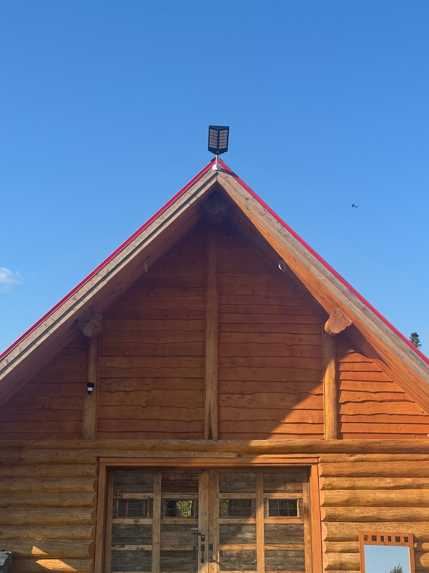 BigM 1200W solar commercial street lights installed at the top of a log cabin