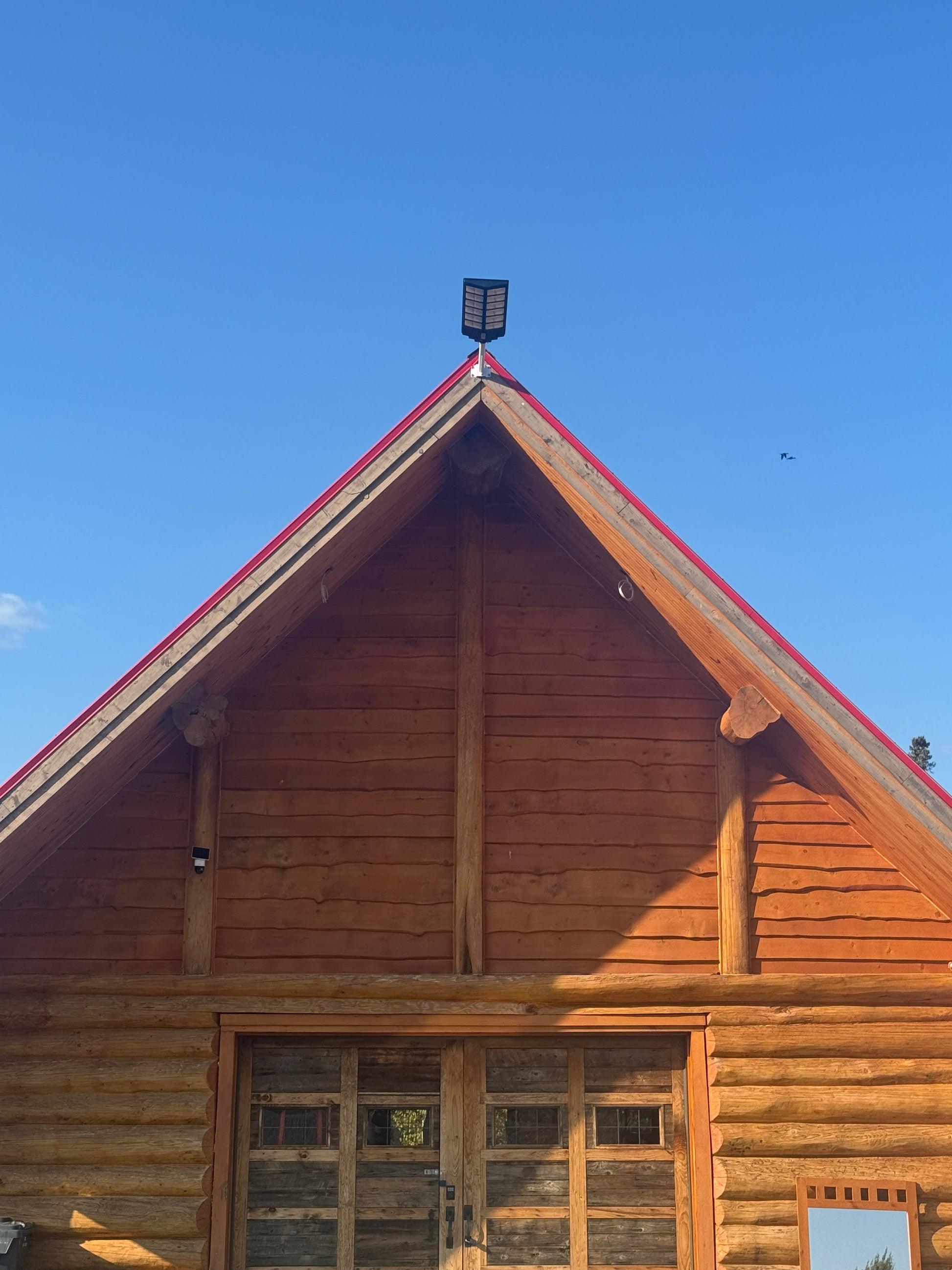 BigM 1200W solar commercial street lights installed at the top of a log cabin