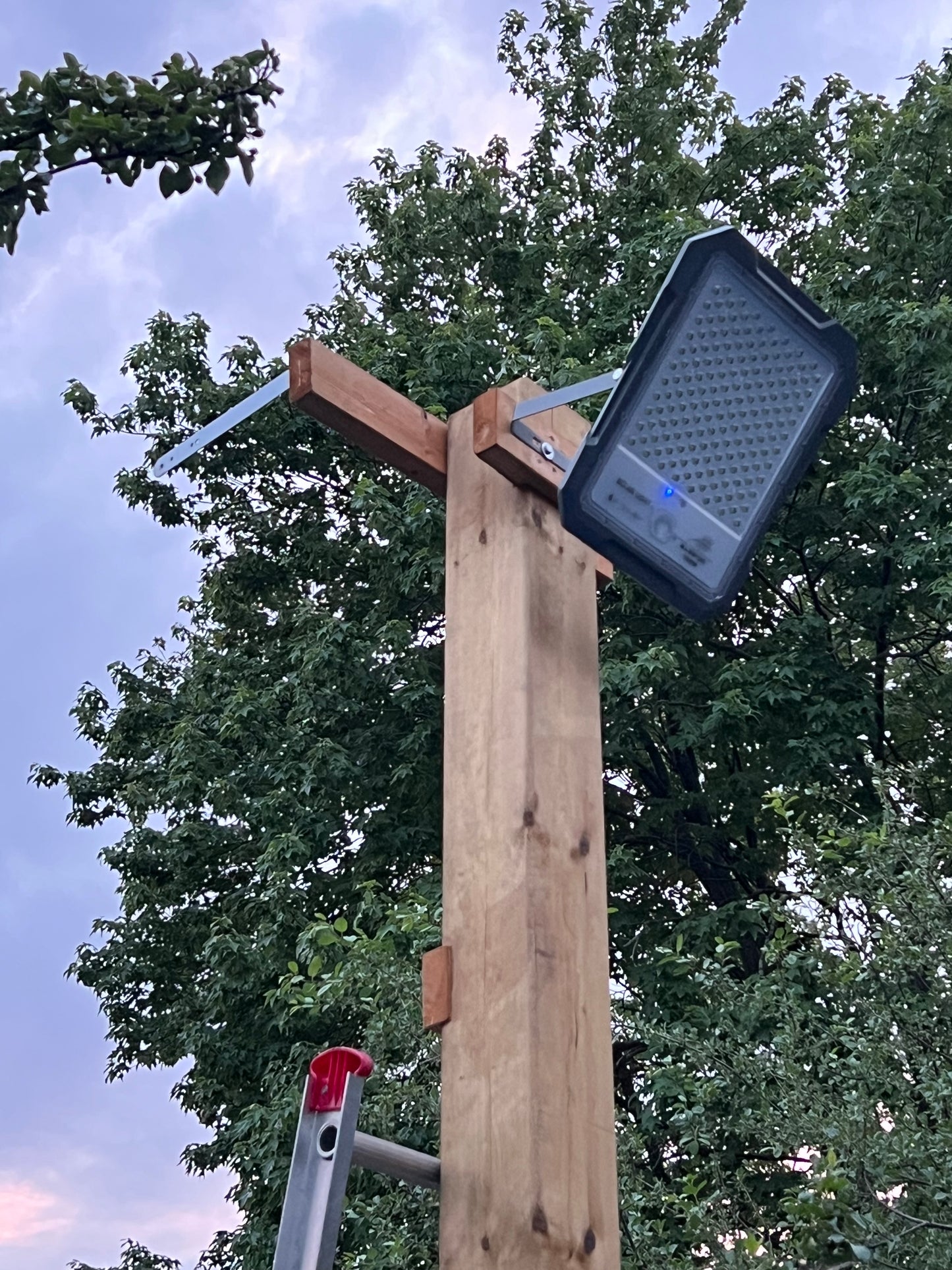 BigM 1500W High Lumens Solar Flood Light is installed on a 6 x 6 post above a picked ball play groud.