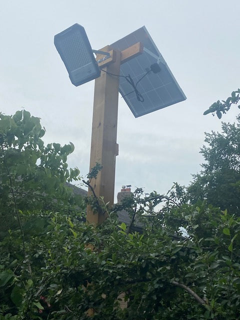 BigM 1500W High Lumens Solar Flood Light is installed on a 6 x 6 post above a picked ball play groud.
