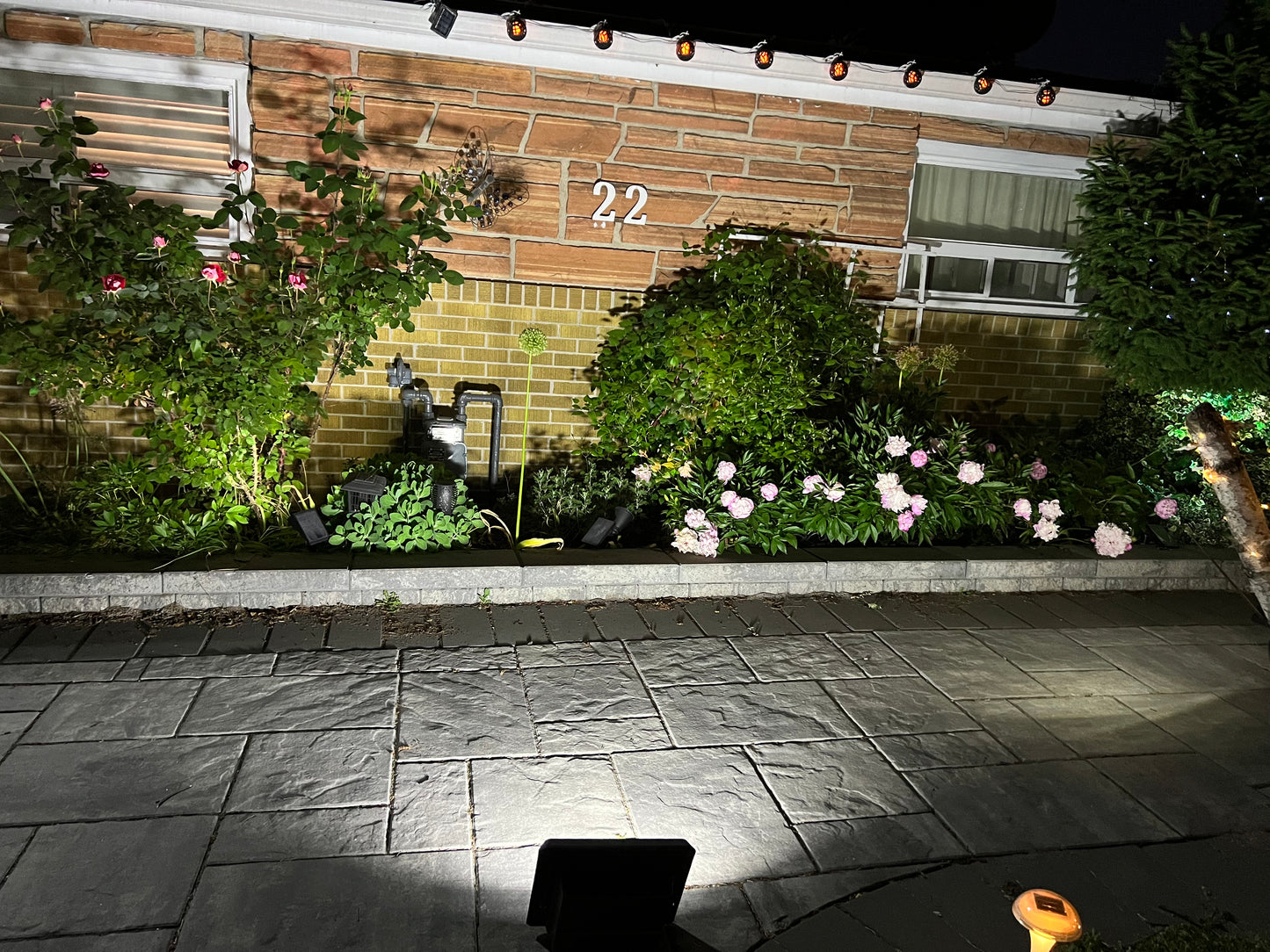 BigM 100W solar bright flood light impressively lights up a house front at night