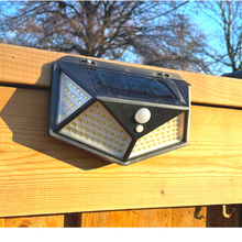 Cargar imagen en el visor de la galería, BigM Super Bright 114 LED Solar Motion Sensor Lights installed on a outdoor fence post
