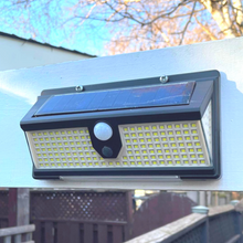 Load image into Gallery viewer, BigM 190 LED Bright Outdoor Solar Security Lights with Motion Sensor installed above a side entrance of a house

