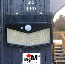 Load image into Gallery viewer, BigM  212 LED Best Solar Security Light is installed on the wall of a house facing backyard
