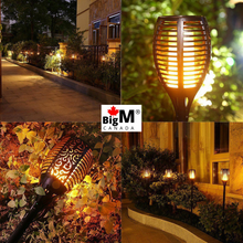 Charger l&#39;image dans la galerie, BigM 96 LED Solar Dancing Flame Lights glowing beautifully in a garden
