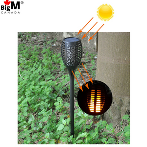 BigM 96 LED Bright Flickering Flame Solar Tiki Torch Lights are installed in a garden