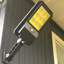 Load image into Gallery viewer, BigM 100W led outdoor solar street light installed on the wall facing backyard of a house
