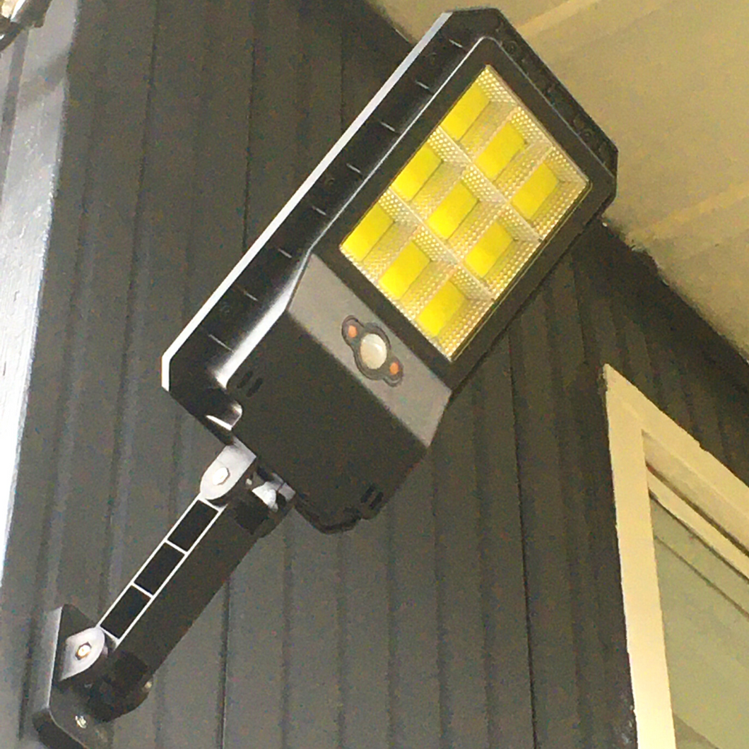 BigM 100W led outdoor solar street light installed on the wall facing backyard of a house