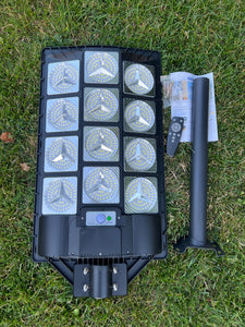 Image of a BigM Heavy Duty 1200W LED Best Solar Street Lights with a metal wall mount, remote, screws, instruction guide