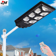 Load image into Gallery viewer, Image of BigM 700W LED Solar Street Light With Remote, Metal Handle, installed on a pole at a Parking lot
