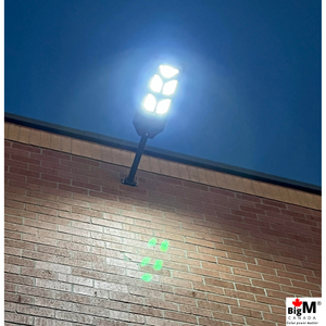 BigM 500w led solar street light generates  bright light at night around a commercial building