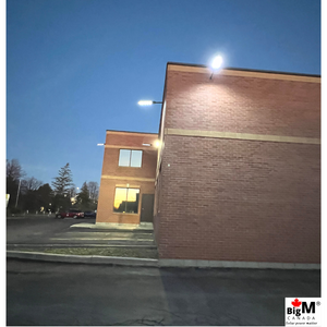 Night image of BigM 500w solar street lights installed around a commercial building