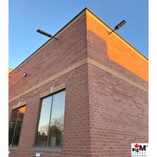 Load image into Gallery viewer, Image of BigM 900W Commercial Grade Solar Street Lights installed at the exterior of a commercial building
