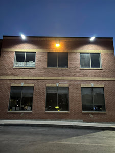 Image of BigM 700w solar parking lot lights lighting up a commercial building and parking lots
