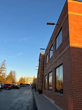 Load image into Gallery viewer, Image of BigM 700w solar parking lot lights are installed at the exterior of a commercial building
