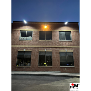 Image of BigM 900W Commercial Grade Solar Street Lights are lighting up a parking lot of a large commercial building