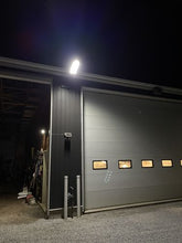 Load image into Gallery viewer, Image of BigM 900W Commercial Grade Solar Street Lights installed at the exterior of a commercial building focusing on the parking lot
