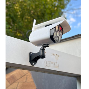 BigM Solar Powered  Fake Security Camera Floodlight is installed above a door
