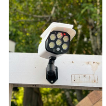 Load image into Gallery viewer, BigM Solar Powered  Fake Security Camera Floodlight with Motion Sensor is installed above a garage door of a house
