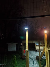 Load image into Gallery viewer, Night view of BigM 100 w street light that being installed by customer on a deck at their cottage
